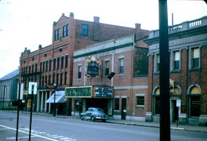 Central Square Theatre in Waltham, MA, featuring a vintage car and surrounding brick buildings.