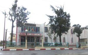 Barbacha town hall in Algeria, with flags and a fence.